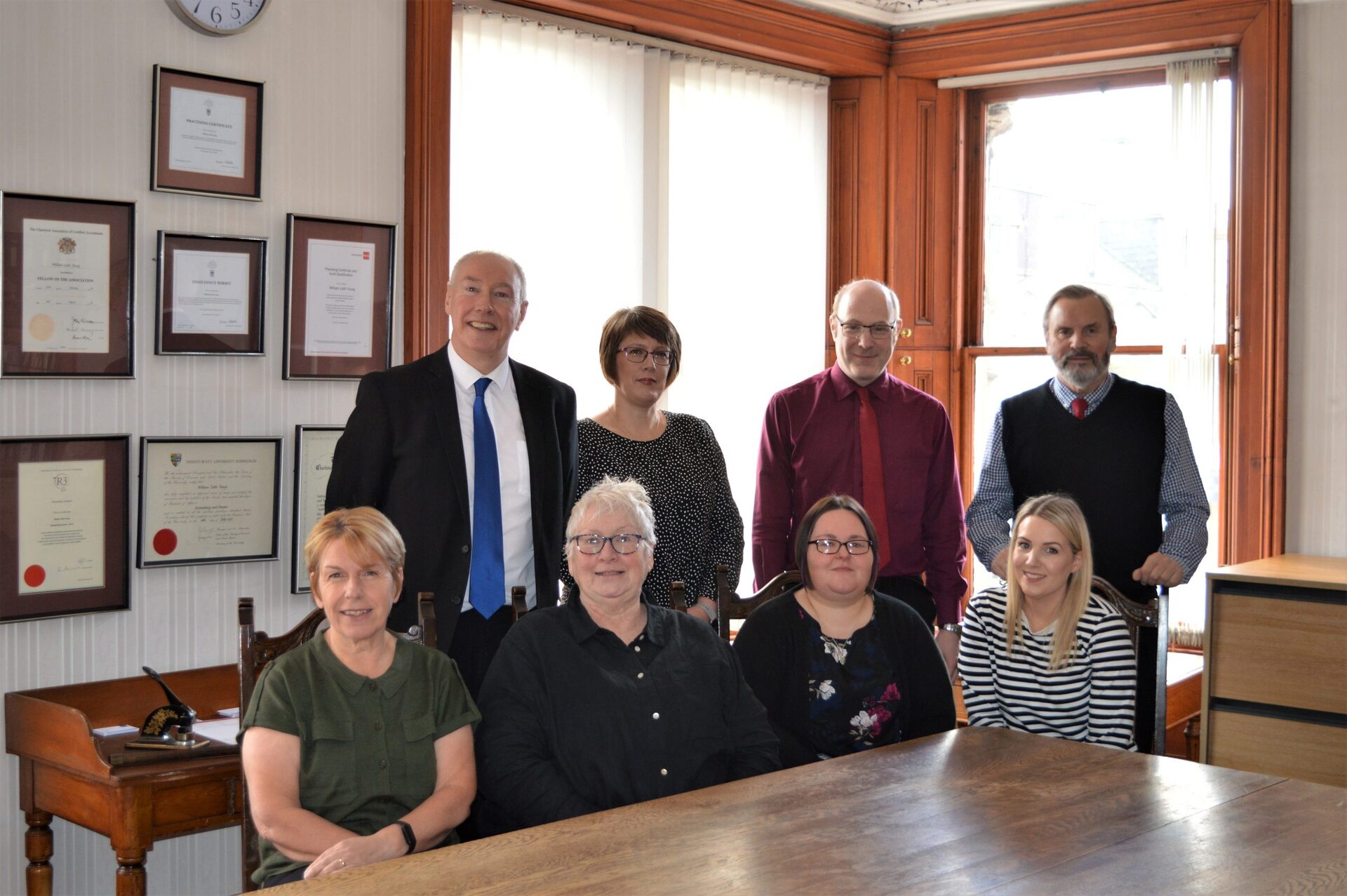 The Ritson Young team gathered around the table in their High Street office in Nairn